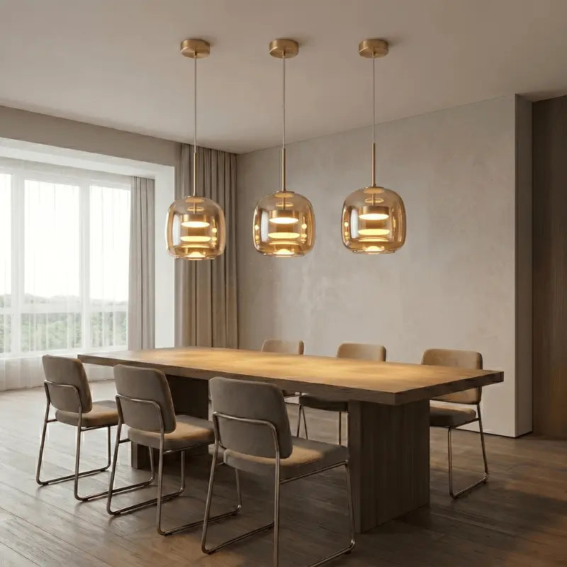 Kit 3 luminárias pendentes vidro âmbar dourado sobre mesa de jantar longa com 6 cadeiras em sala moderna — SmartLuz