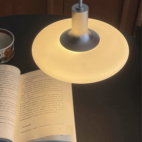 Detalhe superior da luminária pendente em disco opalino com luz quente
