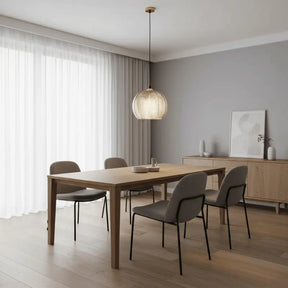 Luminária pendente de vidro canelado âmbar sobre mesa retangular em sala de jantar minimalista com paredes cinzas e piso de madeira
