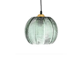 Luminária pendente esférica de vidro canelado verde com cabo preto e acabamento dourado em fundo branco